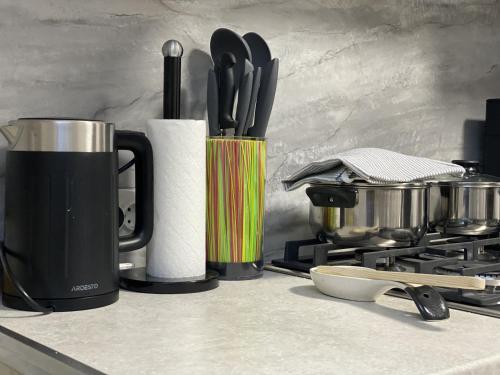 una encimera con taza de café y utensilios de cocina en A&K Retreat Center, en Prilbichi