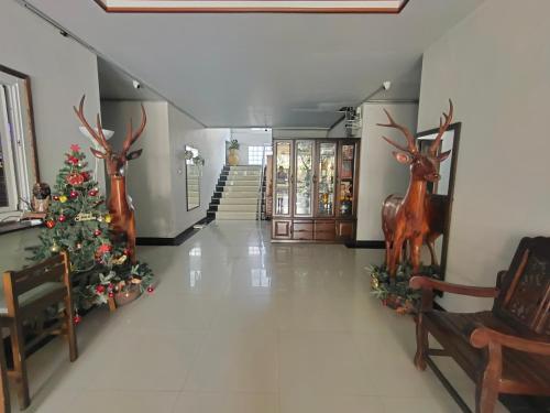 a hall with a christmas tree and reindeer decorations at ห้องพักนครราชสีมา The Rich Room in Ban Pra Dok