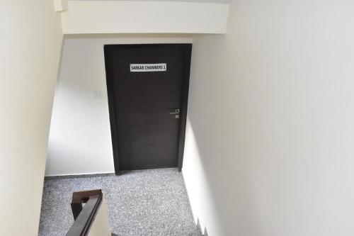 a black door in a hallway with a sign on it at Sarkar Chambers in Mumbai
