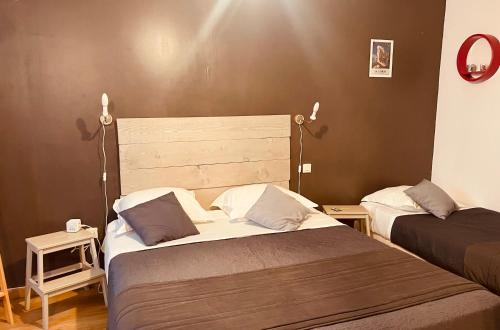 - une chambre avec deux lits et deux lumières sur le mur dans l'établissement Hôtel U Passa Tempu, à Corte