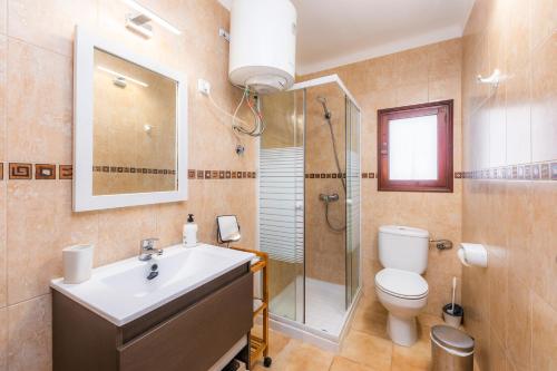 a bathroom with a sink and a toilet and a shower at Casa Can Pinyol in Cala Figuera