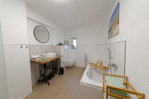 uma casa de banho com uma banheira, um lavatório e um WC. em Casa Eifel em Beilingen