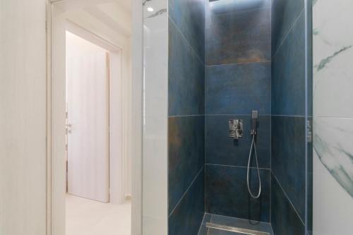 a bathroom with a shower with blue tiles at SithoniaRS Melora Luxury Apartment in Nikiti