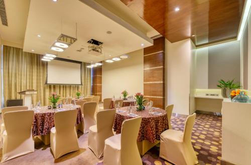 a conference room with tables and chairs and a podium at Novotel Bengaluru Outer Ring Road in Bengaluru