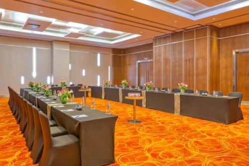a large room with rows of tables and chairs at Novotel Bengaluru Outer Ring Road in Bengaluru