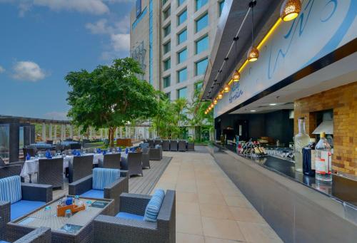 a restaurant with chairs and tables on a building at Novotel Bengaluru Outer Ring Road in Bengaluru