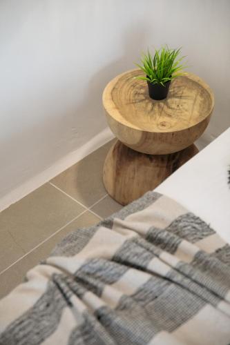 a wooden bowl with a plant sitting on top of a floor at Naxos green Village hotel in Naxos Chora