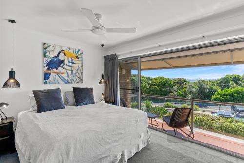 a bedroom with a bed and a large window at surfside6 @ james cook - Clarkes Beach in Byron Bay
