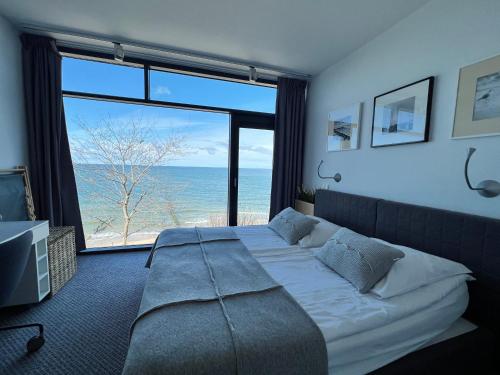 - une chambre avec un lit et une vue sur l'océan dans l'établissement Apartment Morski Widok w Boulevard Ustronie Morskie, à Ustronie Morskie