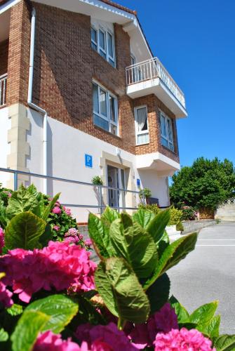 a building with flowers in front of it at Fuente el Hayedo in San Vicente de la Barquera