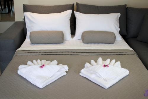 a bed with two white towels on top of it at Amare suite in Perivólia