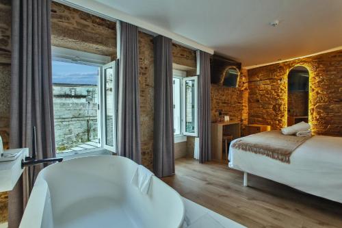 a bedroom with a bed and a large window at Hotel Plaza Obradoiro by Bossh! Hotels in Santiago de Compostela
