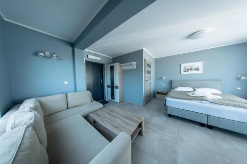 DługieにあるPensjonat Długie Nowicki Rooms & Apartmentsのリビングルーム(ソファ、ベッド付)