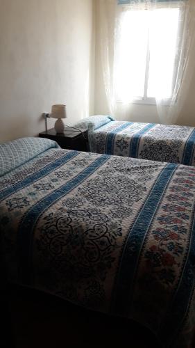 two beds in a room with a window at Desert Escapes in Tabernas