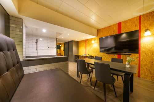 a dining room with a table and chairs and a television at 27 Hotel in Anyang