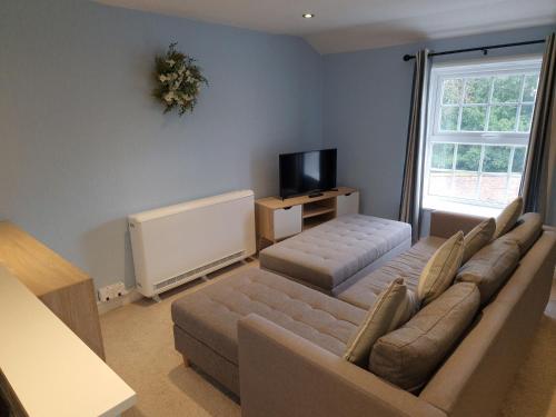 a living room with a couch and a flat screen tv at Gorgeous 1 Bed Apartment in Wetwang in Great Driffield