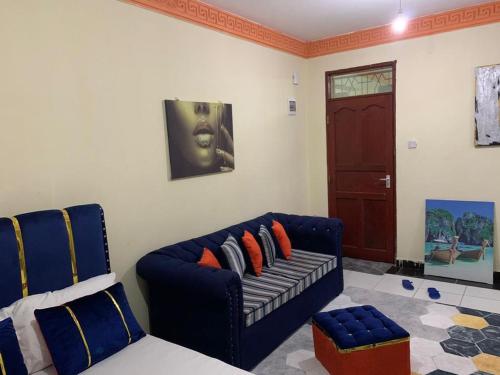 un soggiorno con divano blu e porta di Blue Studios a Mombasa