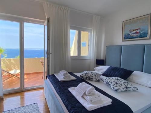 a bedroom with a large bed with towels on it at Sunshine Residence in Stara Baška