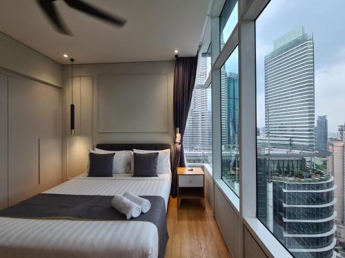 a bedroom with a bed and a large window at Sky Suites KLCC by Asiapex in Kuala Lumpur