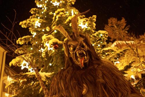 a statue of a statue of a goat in front of a christmas tree at Apartment am See in Zell am See