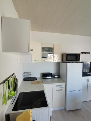 a kitchen with white cabinets and a stove top oven at Pension Haus Erika in Cuxhaven