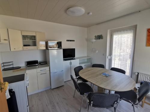 a kitchen and dining room with a table and chairs at Pension Haus Erika in Cuxhaven