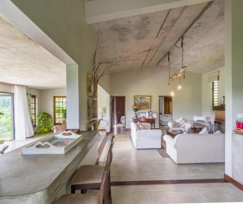 a living room with white furniture and a large ceiling at Green Cottage Chamarel in Chamarel