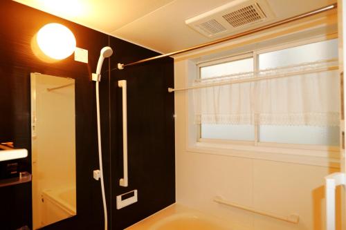 a bathroom with a shower and a window at 東京昭島迎賓館 in Akishima