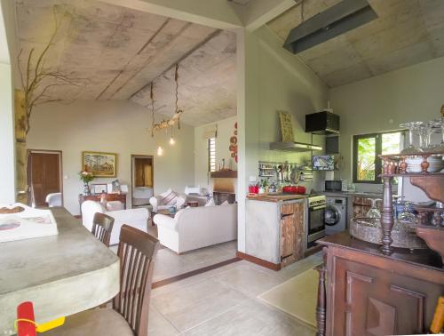 a kitchen and living room with a table and chairs at Green Cottage Chamarel in Chamarel