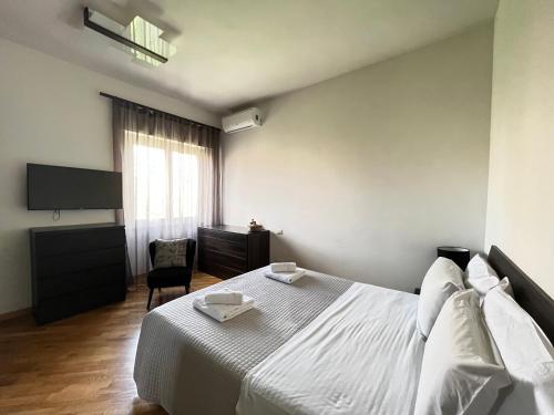 a bedroom with a white bed and a television at Davide Rome Apartment in Rome