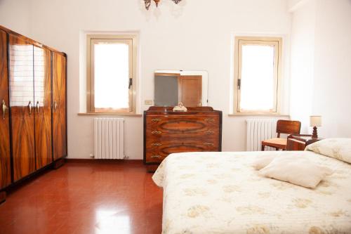 um quarto com uma cama, uma cómoda e 2 janelas em LE PIUME B&B em Cupramontana