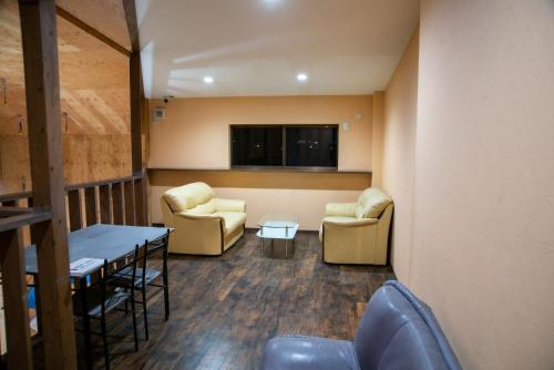 uma sala de espera com sofás e uma mesa e cadeiras em CLIMB INN COCOMO em Sumoto