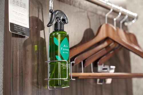 a green bottle of soap hanging on a rack at HOTEL VINE OSAKA KITAHAMA in Osaka