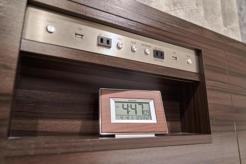 an alarm clock sitting on top of an oven at HOTEL VINE OSAKA KITAHAMA in Osaka