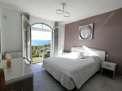 a bedroom with a large bed and a large window at Etoile d'Azur in Sainte-Maxime