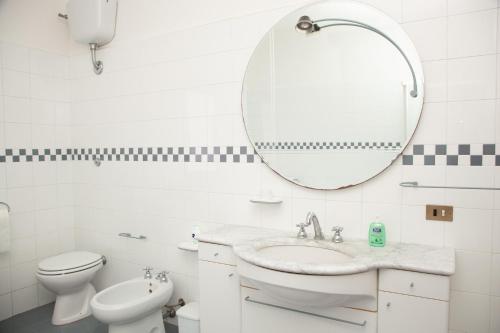 a white bathroom with a sink and a mirror at LE PIUME B&B in Cupramontana