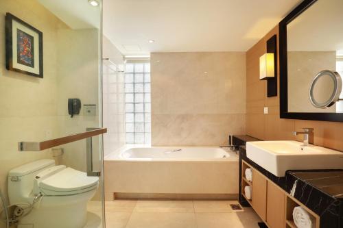 a bathroom with a tub and a toilet and a sink at Crowne Plaza Dhaka Gulshan by IHG in Dhaka