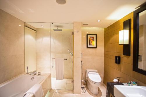 a bathroom with a tub and a toilet and a sink at Crowne Plaza Dhaka Gulshan by IHG in Dhaka