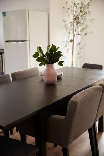 a dining room table with a vase with a plant on it at Enjoy a renovated retreat with outdoor bath in Creswick
