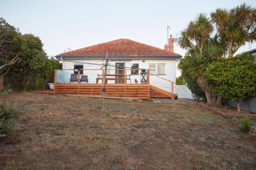 a house with a large wooden deck in a yard at Enjoy a renovated retreat with outdoor bath in Creswick