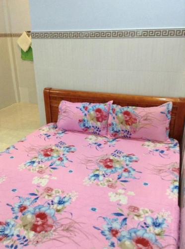 Bett mit rosa Daunendecke und Blumen drauf in der Unterkunft Nhà nghỉ Ngọc Duy Bến Tre in Ben Tre
