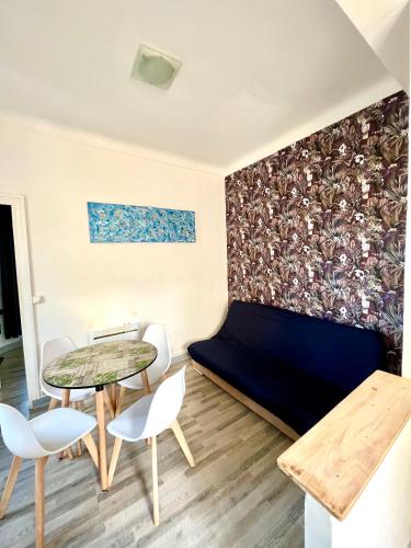 a room with a couch and a table and chairs at Appartement WHITE DESIGN Proche Cannes in Le Cannet