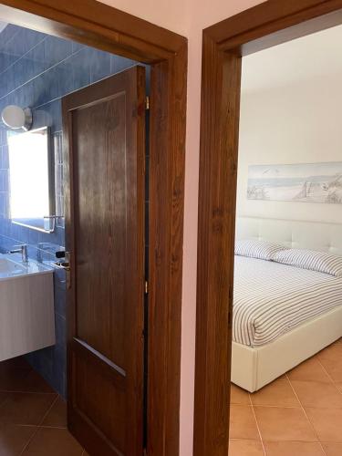 un bagno con porta che conduce a una camera con letto di Casa Fiorella - Vista Mare a Palau