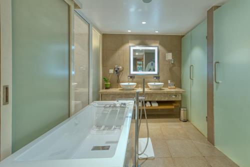 a bathroom with two sinks and a mirror at Novotel Bengaluru Outer Ring Road in Bengaluru