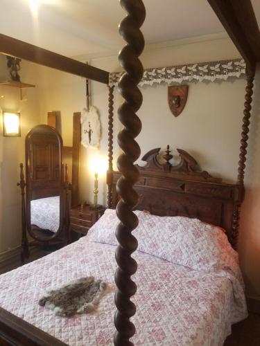 a wooden canopy bed with a cat laying on it at Villa Normandy in Gagny