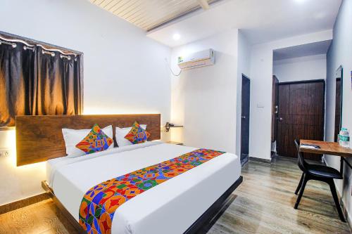 ein Schlafzimmer mit einem Bett und einem Schreibtisch. in der Unterkunft FabHotel W Grand Suites in Hyderabad