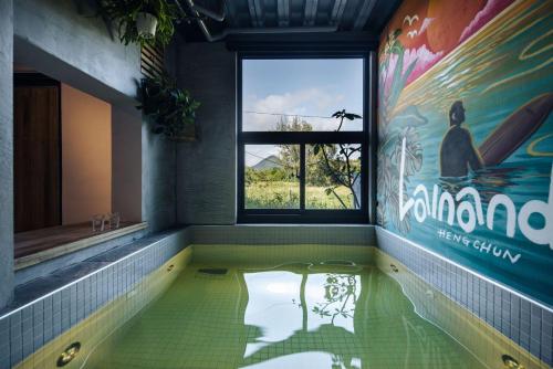 a bathroom with a hot tub with a window at Lainandao Villa in Hengchun