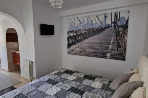 een slaapkamer met een bed met een foto aan de muur bij Moderne geräumige Ferienwohnung in der Villa Fortuna in Calpe