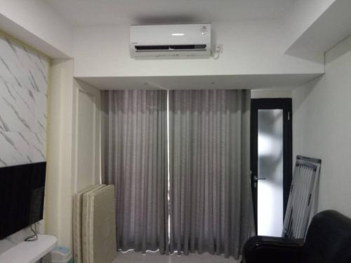 a living room with a ceiling fan and a window at 1 Bed Apartment Pollux for Rent in Kangboi