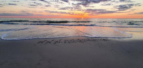 a sunset on the beach with the words thank you written in the sand at HeidAway Sylt - Schönes Appartment mit Terrasse/Garten in Braderup